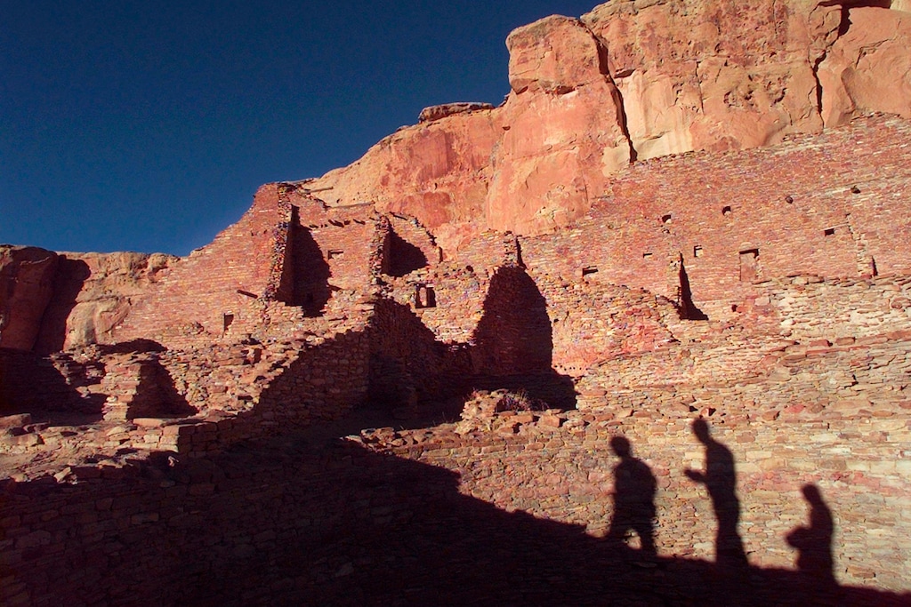 (Eric Draper | AP file photo) Tourists cast their shadows on the ancient Anasazi ruins of Chaco Culture National Historical Park in New Mexico, Nov. 21, 1996. Lawmakers from the country's largest American Indian reservation may have thrown a wrinkle into efforts aimed at establishing a permanent buffer around the national park as New Mexico's congressional delegation, environmentalists and other tribes try to keep oil and gas development from getting closer to the World Heritage site. Navajo Nation delegates voted Thursday, Jan. 23, 2020, to support a buffer only half the size of the one proposed in legislation pending in Congress.