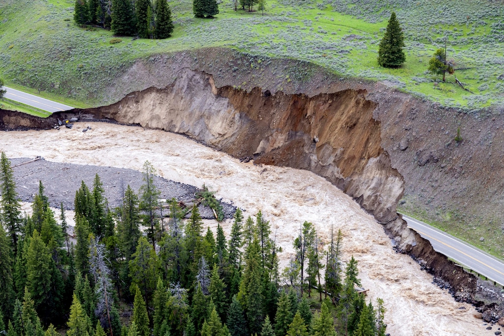 (Jacob W. Frank | National Park Service) Flooding waters wash out North Entrance Road at Yellowstone National Park in Gardiner, Mont., on June 13, 2022. Flooding caused by heavy rains over the weekend caused road and bridge damage in Yellowstone National Park, leading park officials to close all the entrances through at least Wednesday. Gardiner, a town just north of the park, was isolated, with water covering the road north of the town and a mudslide blocking the road to the south.