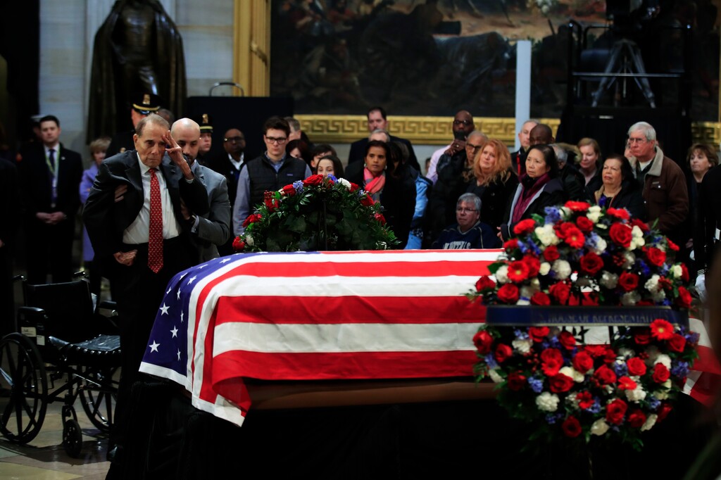 (Manuel Balce Ceneta | The Associated Press) Former Sen. Bob Dole salutes the flag-draped casket containing the remains of former President George H.W. Bush as he lies in state at the U.S. Capitol in Washington, Tuesday, Dec. 4, 2018.