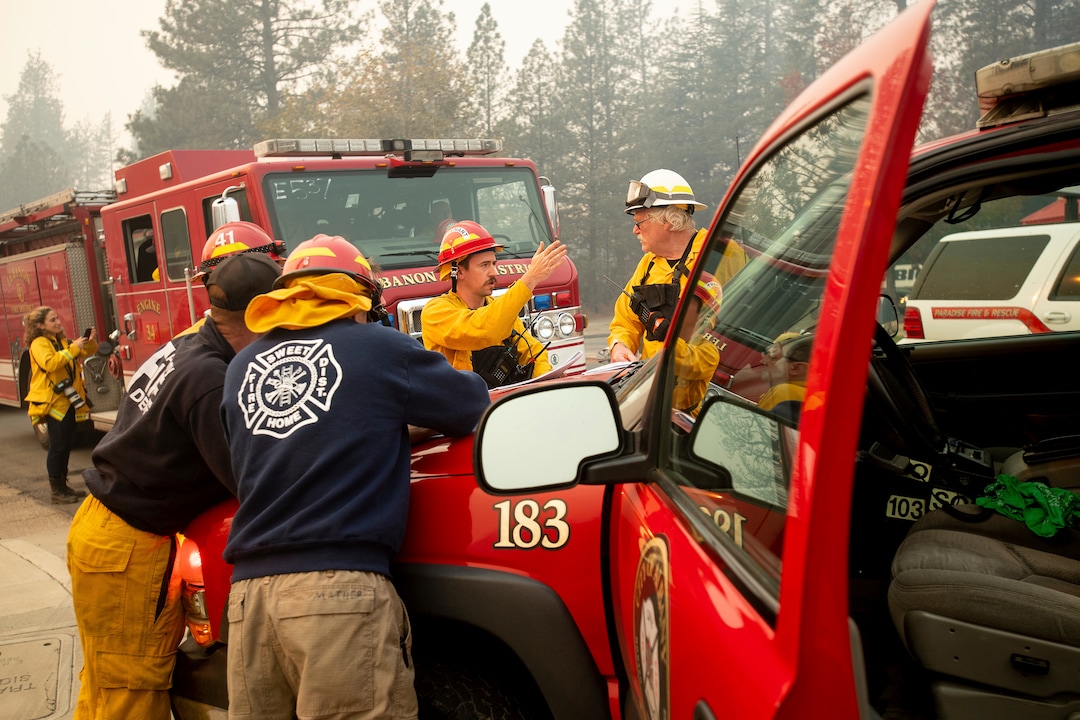 Firefighters plan their operations while battling the Camp Fire in Paradise, Calif., on Saturday, Nov. 10, 2018.  The blaze that started Thursday outside the hilly town of Paradise has grown and destroyed more than 6,700 buildings, almost all of them homes, making it California's most destructive wildfire since record-keeping began. But crews have made gains and the fire is partially contained, officials said Saturday. (AP Photo/Noah Berger)