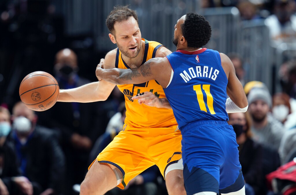 Utah Jazz forward Bojan Bogdanovic, left, looks to pass the ball as Denver Nuggets guard Monte Morris defends in the first half of an NBA basketball game Wednesday, Jan. 5, 2022, in Denver. (AP Photo/David Zalubowski)