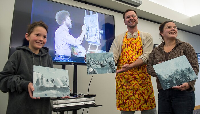 (Leah Hogsten  |  The Salt Lake Tribune) Quinton, left, Randy and Lori Block pose for a picture  during a Bob Ross Paint-Along class, Saturday, Jan. 6, 2018, at the Salt Lake City Public Library's Sweet Branch in the Avenues.