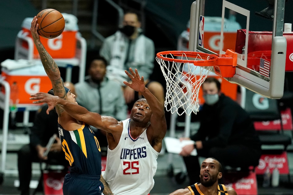 Utah Jazz guard Jordan Clarkson, left, goes up for a dunk as Los Angeles Clippers forward Mfiondu Kabengele (25) defends during the second half of an NBA preseason basketball game Thursday, Dec. 17, 2020, in Los Angeles. (AP Photo/Marcio Jose Sanchez)