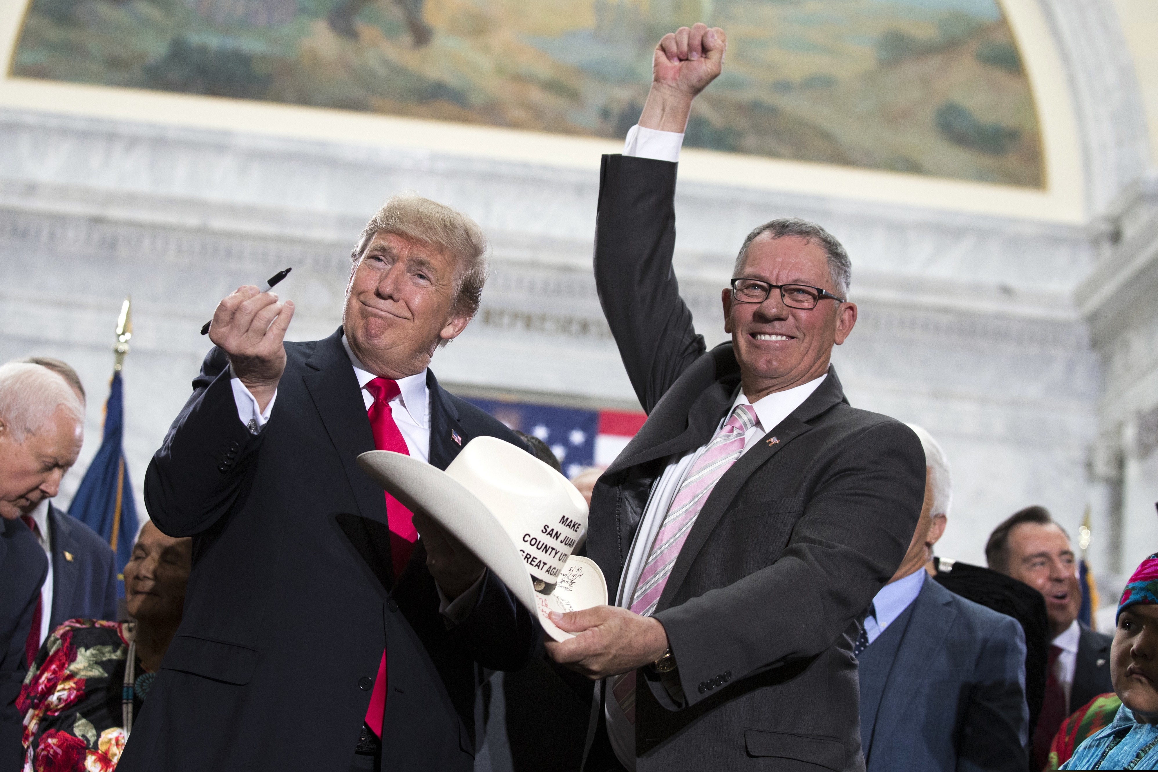 (Evan Vucci | AP file photo) In this Dec. 4, 2017, file photo, President Donald Trump signs the hat of Bruce Adams, chairman of the San Juan County Commission, after speaking about his decision to shrink the size of Bears Ears and Grand Staircase Escalante national monuments. "We were thrilled to meet the President and attend the signing ceremony at the state Capitol," Adams said in his recent GOP primary race.