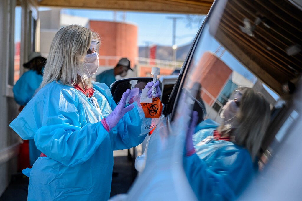 (Trent Nelson  |  The Salt Lake Tribune) Jennie McQueen administers a COVID-19 saliva test at a new testing station at Rice-Eccles Stadium in Salt Lake City on Monday, Oct. 12, 2020.