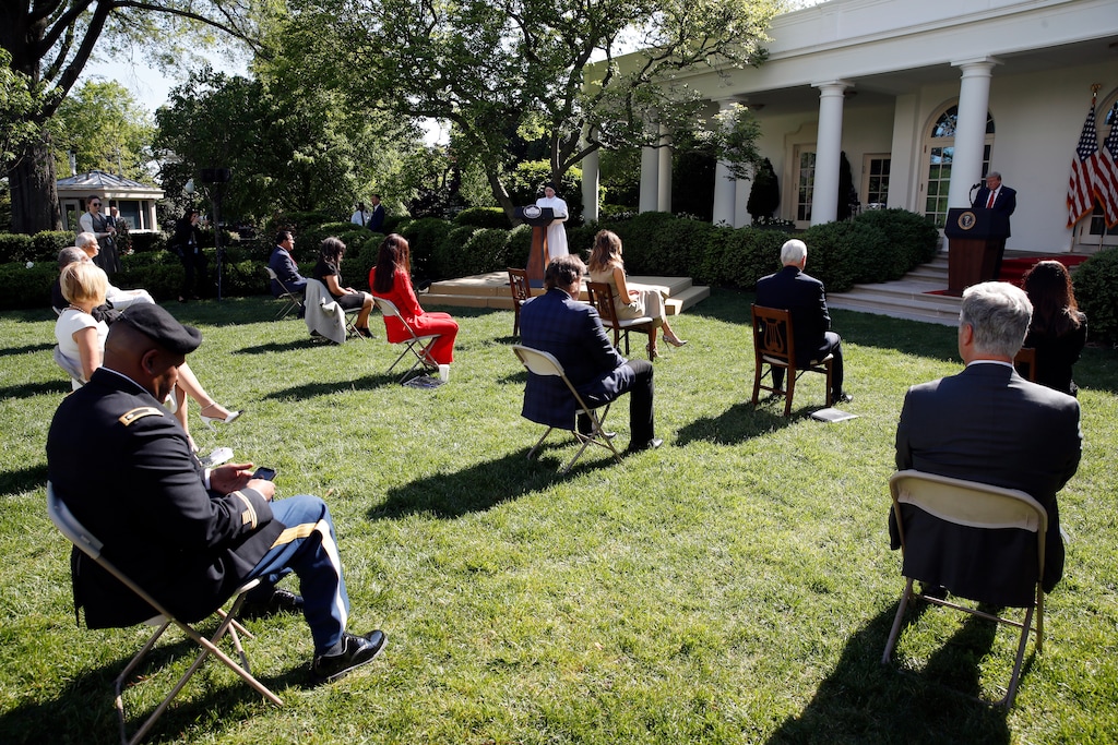 (Alex Brandon | The Associated Press) President Donald Trump listens as Sister Eneyda Martinez, with Poor Sisters of St. Joseph, at left podium, speaks during a White House National Day of Prayer Service in the Rose Garden of the White House, Thursday, May 7, 2020, in Washington.
