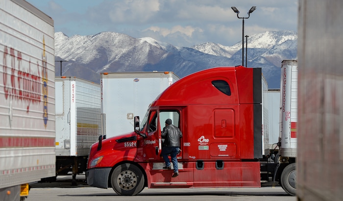 (Francisco Kjolseth | The Salt Lake Tribune) A driver gets in to his rig as trucks come and go at C.R. England trucking in Salt Lake City on Monday, March 30, 2020. The coronavirus outbreak has helped make truckers heroes as they help to stock empty shelves in stores. Drivers face new challenges from finding restrooms and food on the road amid shutdowns, but say they enjoy driving with no congestion.