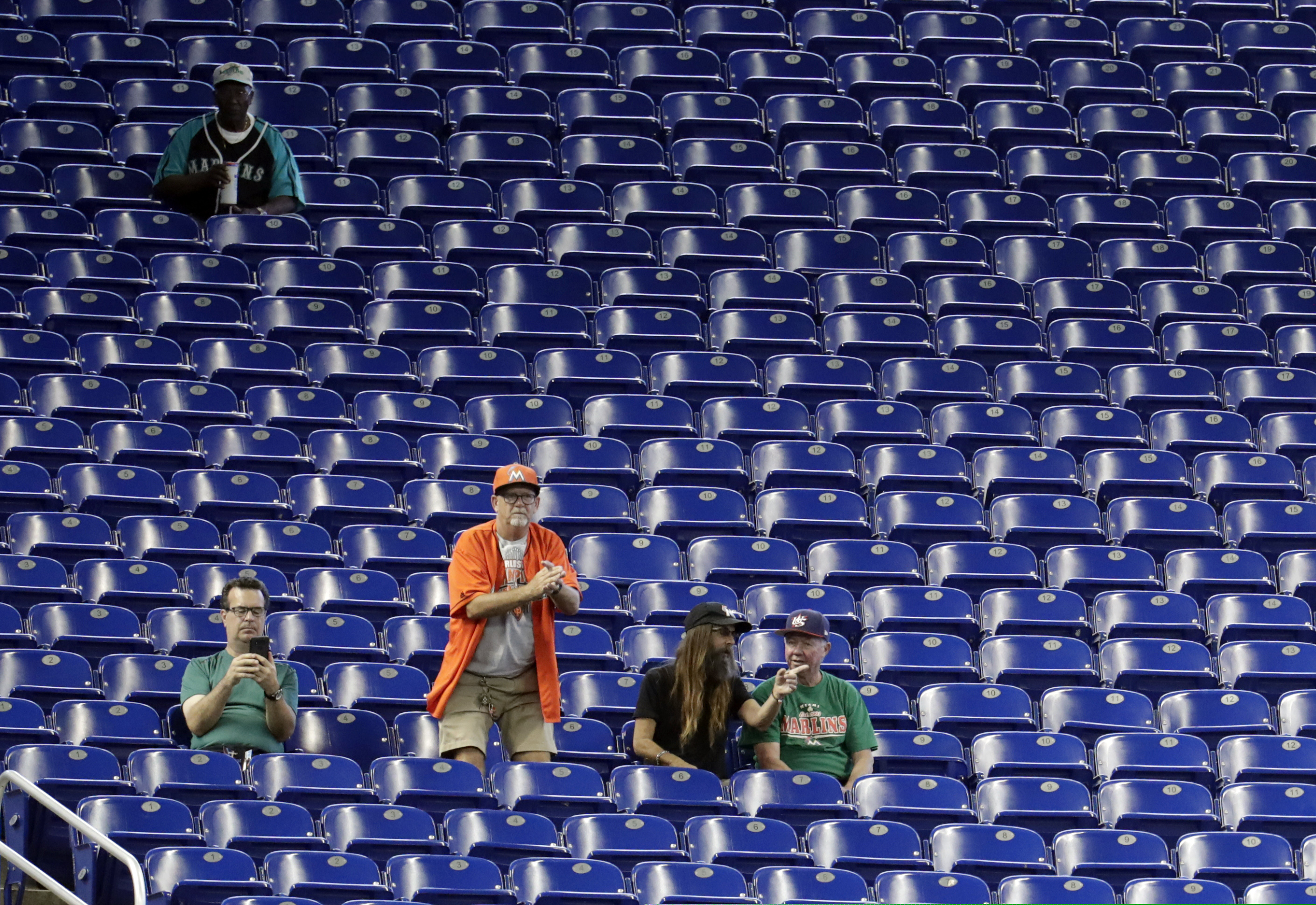 Fans watch a baseball game between the Miami Marlins and San Francisco Giants, Thursday, May 30, 2019, in Miami. Major League Baseball's average attendance of 26,854 is 1.4% below the 27,242 through the similar point last season, which wound below 30,000 for the first time since 2003. Baltimore, Cincinnati, Minnesota and Tampa Bay set stadium lows this year. Kansas City had its smallest home crowd since 2011, and Toronto and San Francisco since 2010. Miami and the Rays drew 12,653 Wednesday night _ combined. (AP Photo/Lynne Sladky)