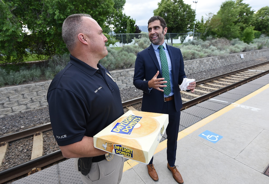(Francisco Kjolseth | Tribune file photo) In this June 1, 2018, file photo, Sandy Mayor Kurt Bradburn, right, teams up with the late Police Chief Bill O'Neal to hand out treats in celebration of 'National Doughnut Day,' at the Sandy Civic Center TRAX Station.