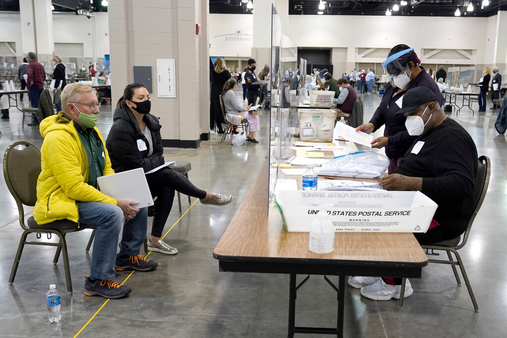 (Nam Y. Huh | AP file photo) Election workers, right, verify ballots as recount observers watch during a Milwaukee hand recount of presidential votes at the Wisconsin Center, Friday, Nov. 20, 2020, in Milwaukee. Wisconsin finished a partial recount of its presidential results on Sunday, Nov. 29, 2020 confirming Democrat Joe Biden's victory over President Donald Trump in the key battleground state. Trump vowed to challenge the outcome in court.