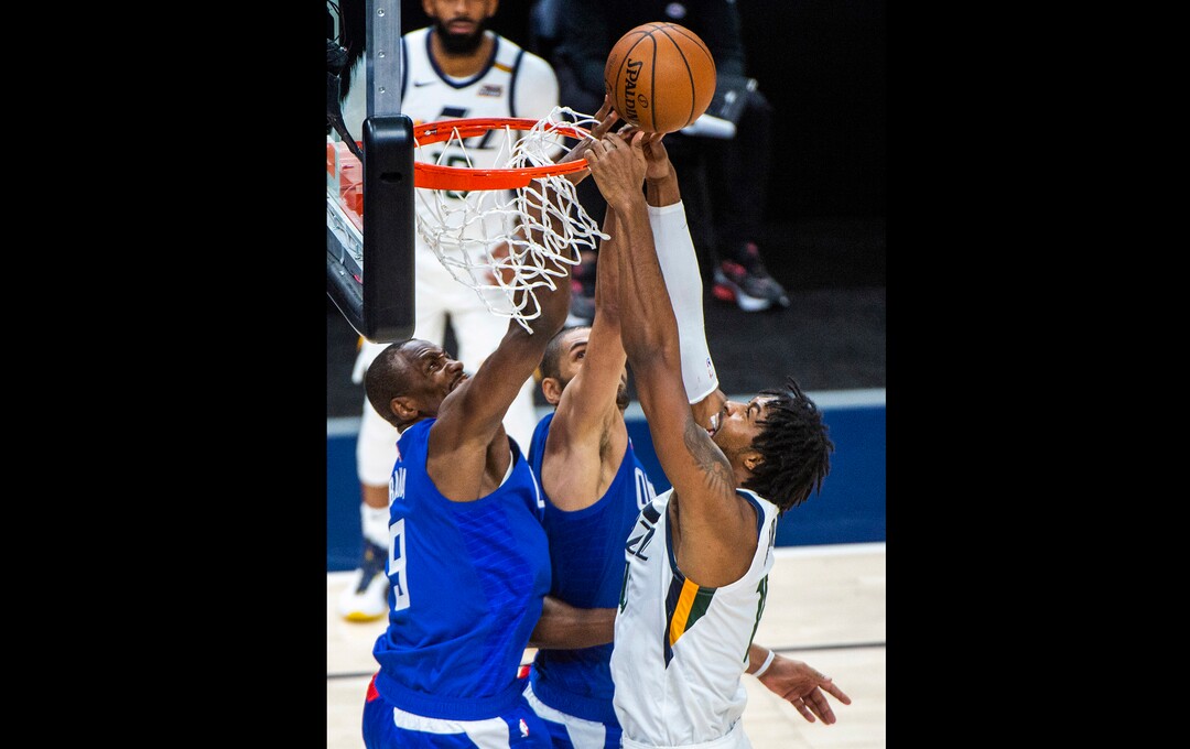 (Rick Egan | The Salt Lake Tribune) LA Clippers forward Serge Ibaka (9) sticks his hand inside the hoop to stop Utah Jazz center Derrick Favors (15) from scoring, in NBA action between the Utah Jazz and the LA Clippers at Vivint Arena, on Friday, Jan. 1, 2021.