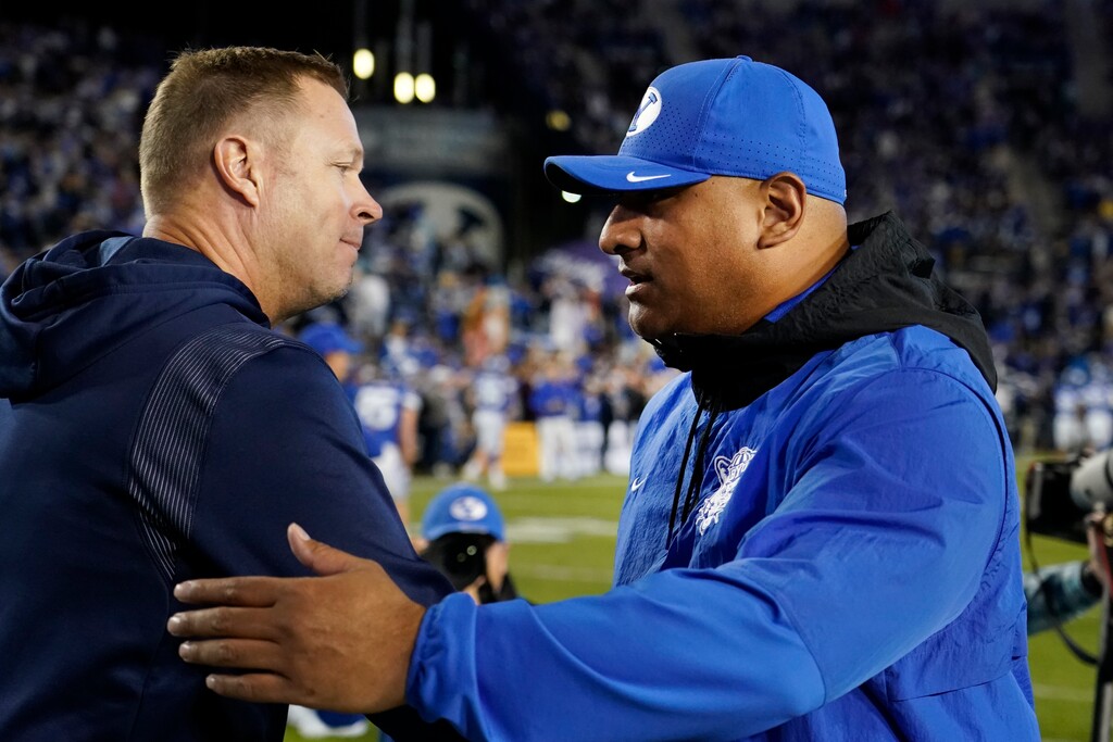 (George Frey | AP) Virginia coach Bronco Mendenhall, left, greets BYU coach Kalani Sitake before an NCAA college football game Saturday, Oct. 30, 2021, in Provo, Utah. Mendenhall formerly coached at BYU.