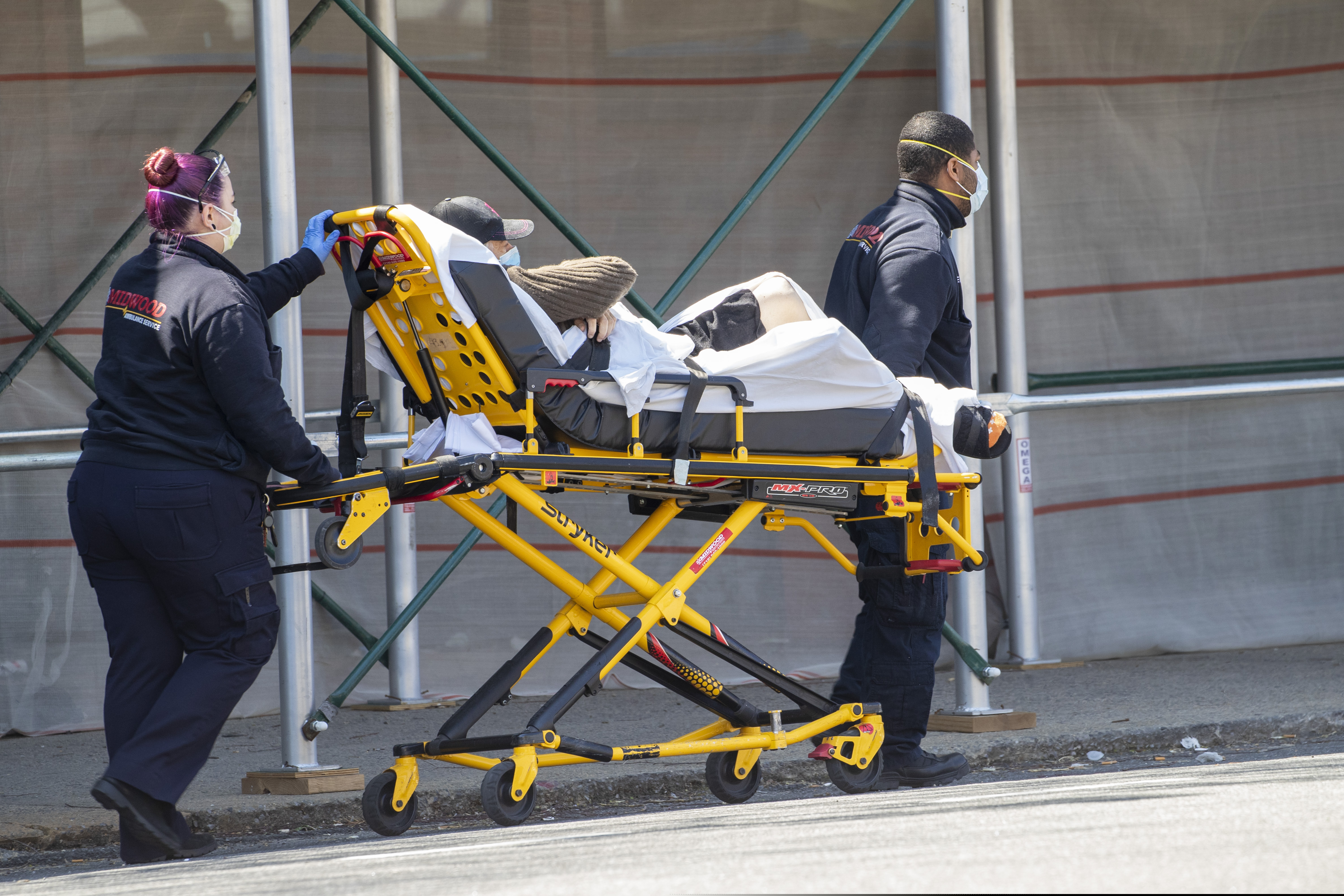 Medics transport a patient to the King David Center for Nursing and Rehabilitation in the Gravesend neighborhood of the Brooklyn borough of New York, Wednesday, April 15, 2020. Federal health officials are coming under increasing pressure to start publicly tracking coronavirus infections and deaths in nursing homes amid criticism they have not been transparent about the scope of outbreaks across the country that have already claimed thousands of lives. (AP Photo/Mary Altaffer)