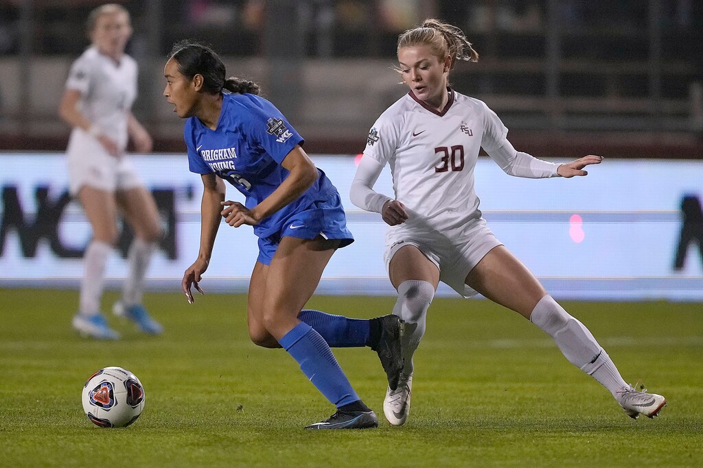 BYU's Laveni Vaka, left, moves the ball past Florida State's Beata Olsson (30) during the first half in the NCAA College Cup women's soccer final Monday, Dec. 6, 2021, in Santa Clara, Calif. (AP Photo/Tony Avelar)