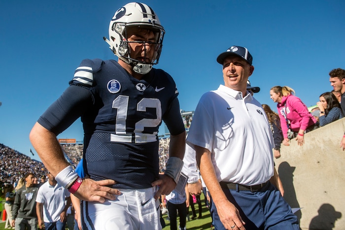 (Chris Detrick  |  The Salt Lake Tribune)  Offensive Coordinator and Quarterbacks Coach Ty Detmer talks with Brigham Young Cougars quarterback Tanner Mangum (12) during the game at LaVell Edwards Stadium Saturday, October 28, 2017.  