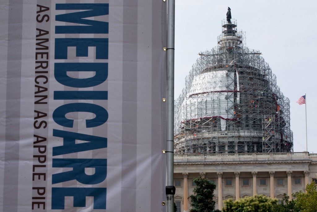 FILE - In this July 30, 2015 file photo, a sign supporting Medicare is seen on Capitol Hill in Washington. A government report says Medicare beneficiaries can end up with higher hospital bills for some medical services as outpatients than as inpatients. In the topsy-turvy world of Medicare billing, you may pay more for outpatient care. (AP Photo/Jacquelyn Martin, File)