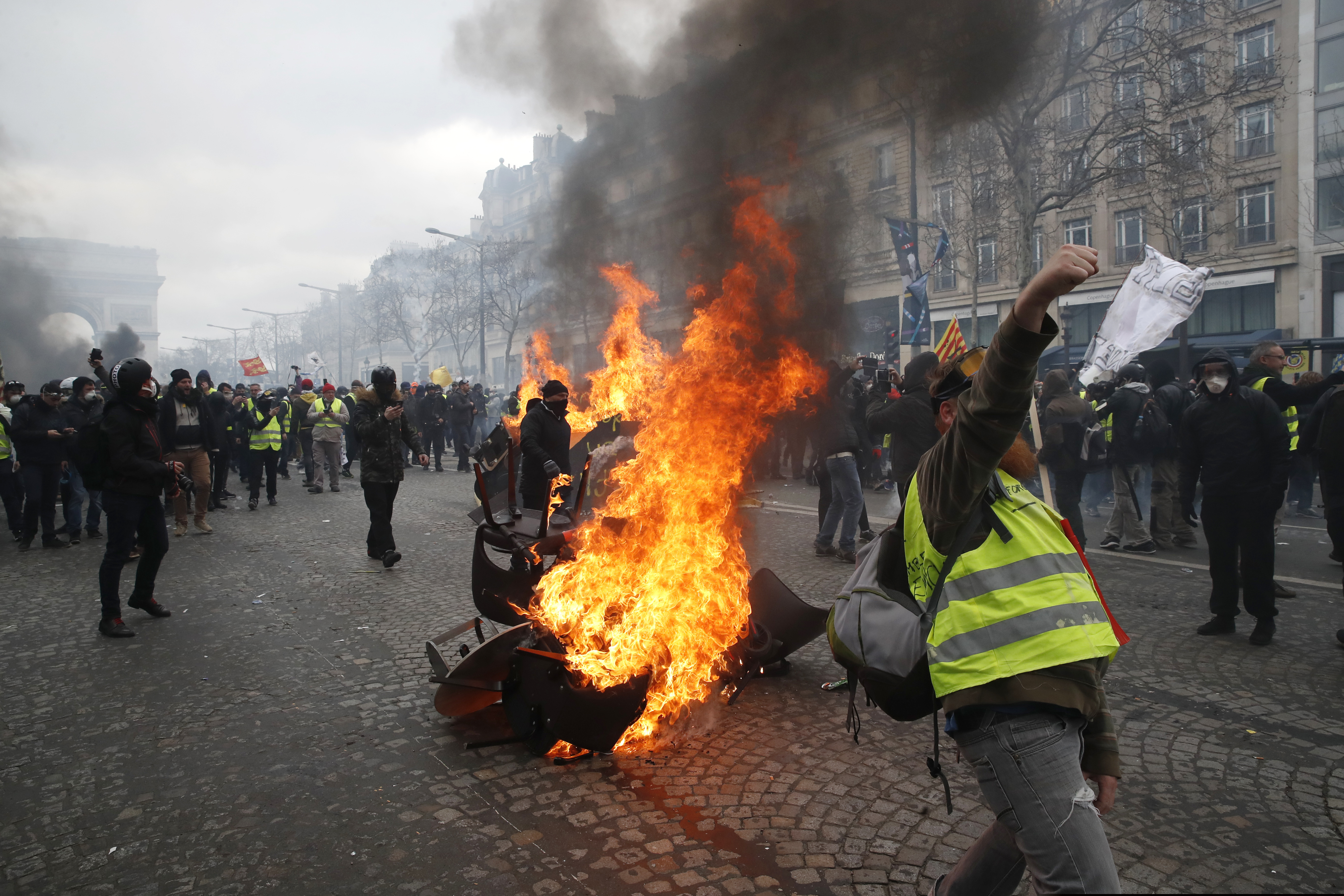 (AP Photo/Christophe Ena) A barricade burns on the Champs Elysees avenue Saturday, March 16, 2019 in Paris. French yellow vest protesters clashed Saturday with riot police near the Arc de Triomphe as they kicked off their 18th straight weekend of demonstrations against President Emmanuel Macron.
