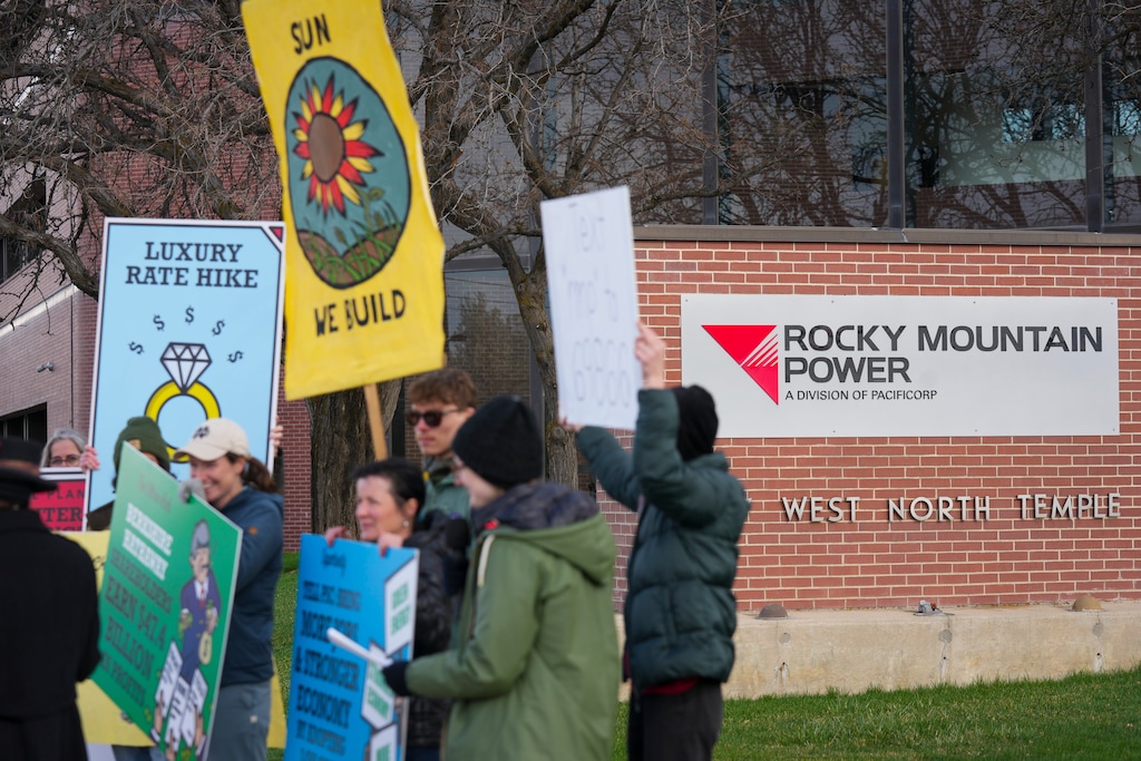 (Bethany Baker  |  The Salt Lake Tribune) Protesters gather during a Monopoly-themed rally to protest utility-driven rate hikes and obstacles to renewable energy at the corporate headquarters for Rocky Mountain Power in Salt Lake City on Tuesday, April 1, 2025.