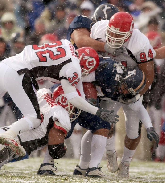 (Trent Nelson  |  Tribune file photo)  Utah defenders Eric Weddle (top left), Sione Pouha (bottom left) and Steve Fifita (top right) bring down BYU's Marcus Whalen during the BYU Utah game on Saturday November 22, 2003 at LaVell Edwards Stadium.