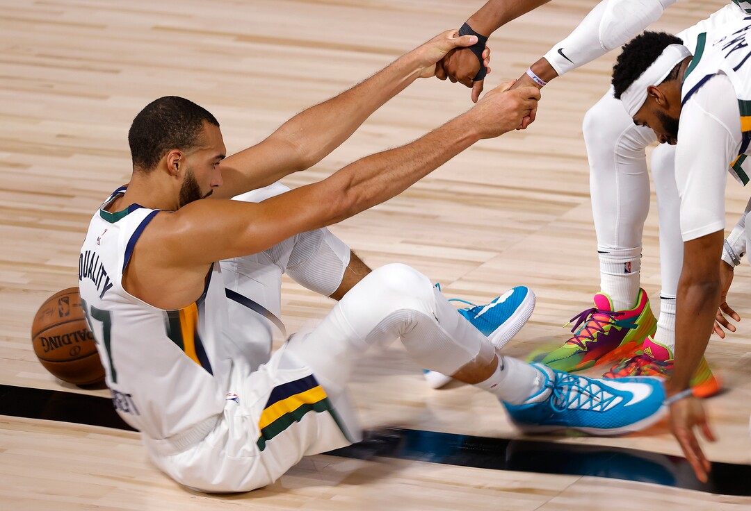 Utah Jazz's Rudy Gobert #27 of the Utah Jazz is helped off of the floor during the fourth quarter against the Denver Nuggets in Game 5 of an NBA basketball first-round playoff series, Tuesday, Aug. 25, 2020, in Lake Buena Vista, Fla. (Mike Ehrmann/Pool Photo via AP)