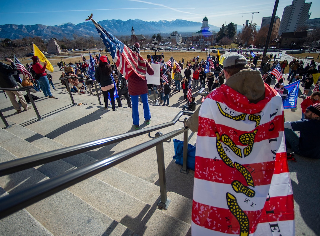 (Rick Egan | The Salt Lake Tribune). A small crowd of Trump protesters gather at the capitol with signs, flags and guns on Wednesday, Jan. 6, 2021.
