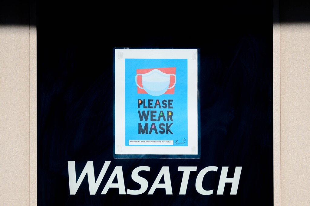 (Trent Nelson  |  The Salt Lake Tribune) A sign asks customers to wear masks during the current yellow (low-risk) phase of Utah's COVID-19 effort, at Wasatch Running Center in Sandy on Tuesday, June 23, 2020.