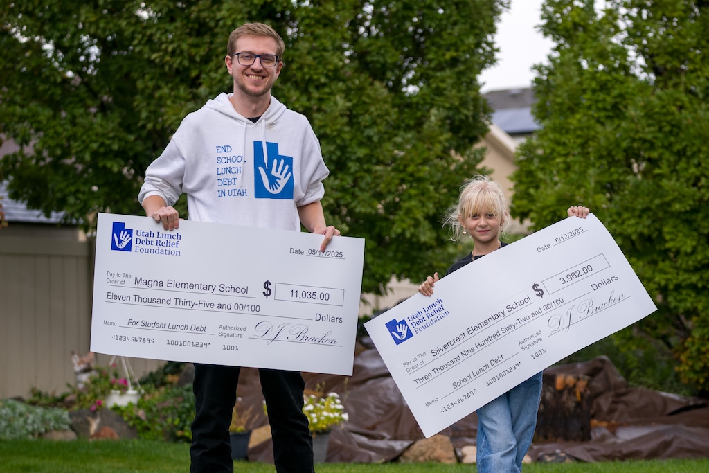 (Trent Nelson  |  The Salt Lake Tribune) DJ Bracken, founder of the Utah Lunch Debt Relief Foundation, and his daughter, Liara Bracken holding checks to local elementary schools, in Riverton on Tuesday, Sept. 30, 2025.