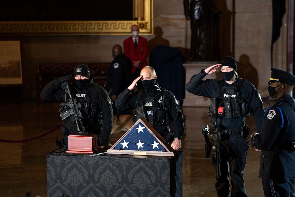 (Anna Moneymaker | The New York Times via AP)
In this Wednesday, Feb. 3, 2021, photo, Capitol Police officers pay respects to the late U.S. Capitol Police officer Brian Sicknick as an urn with his cremated remains lies in honor on a black-draped table at the center of the Capitol Rotunda in Washington.