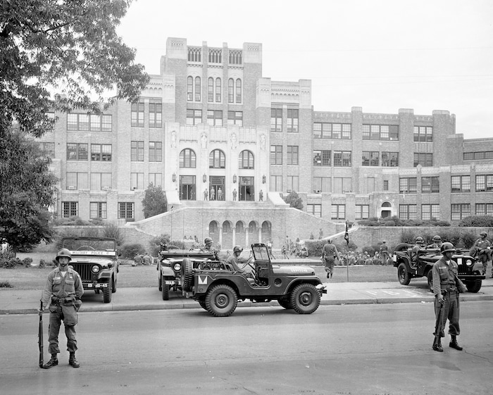 FILE - In this Sept. 26, 1957, file photo, members of the 101st Airborne Division take up positions outside Central High School in Little Rock, Ark., after President Dwight D. Eisenhower ordered them into the city to enforce integration at the school. The 60th anniversary of the school's desegregation is Monday, Sept. 25, 2017. (AP Photo/File)