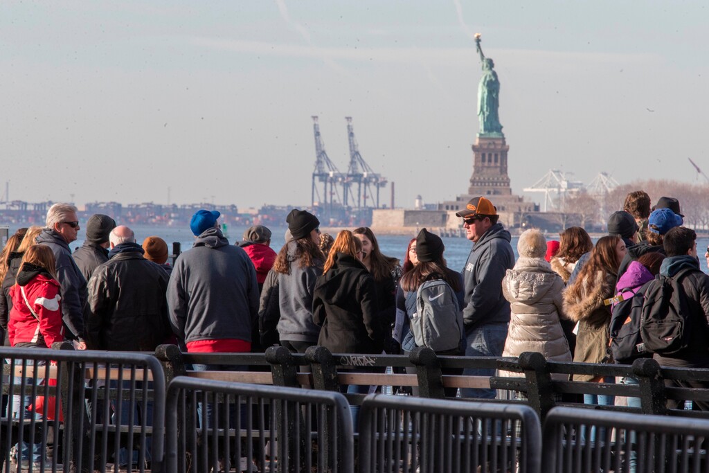 (Mary Altaffer | Associated Press file photo)  In this Jan. 20, 2018, file photo, visitors to the Statue of Liberty stand in line to board a ferry that will cruise the bay around the statue and Ellis Island in New York.
