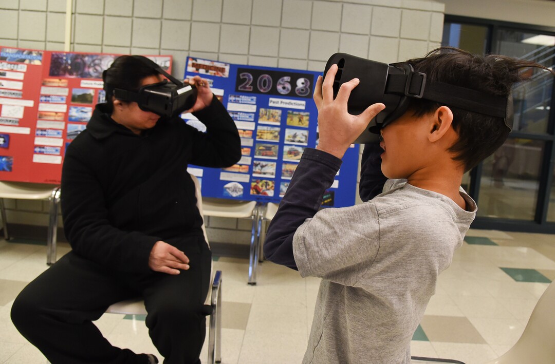 (Francisco Kjolseth  |  The Salt Lake Tribune)  Jonas Orbiso and his son Anthony, 7, immerse themselves in a virtual world as Salt Lake City's Winter De-Stressor Festival at the Horizonte Instruction and Training Center on Saturday, Dec. 15, 2018. The event helped families identify and locate services for youths during between Christmas and New Years. When school is out for winter break, it can have an impact on the state's most vulnerable populations who face food insecurity, access to healthcare services, affordable childcare and safe places for their children.