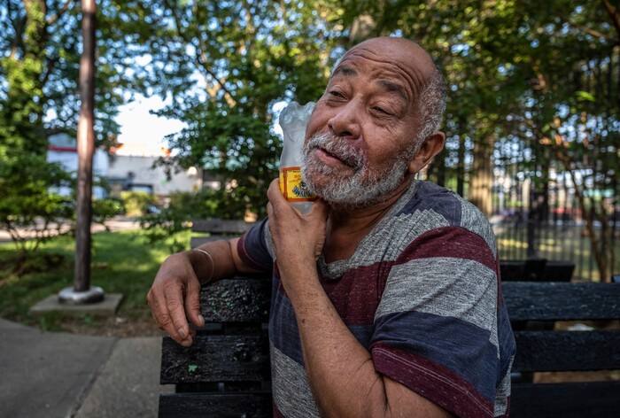 (Juan Arredondo | The New York Times) Rafael Velasquez, a retired cook who lives alone since his wife passed, uses a cold water bottle to cool down outside the Carter G. Woodson Senior house in Brooklyn, July 23, 2020. Around the world, the poor and marginalized are much more likely to be vulnerable to extreme heat; Black people and Latinos like Velasquez are far more likely to live in the hottest parts of American cities.