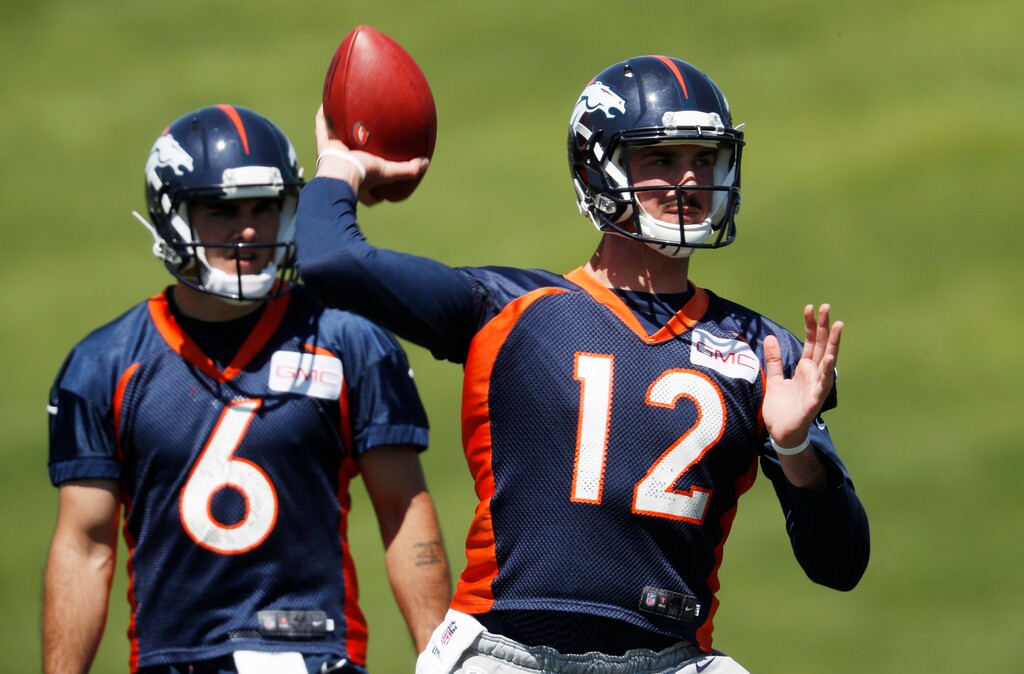 Denver Broncos quarterback Paxton Lynch, front, throws during drills as quarterback Chad Kelly looks on at the NFL football team's training camp Wednesday, June 13, 2018, in Englewood, Colo. (AP Photo/David Zalubowski)