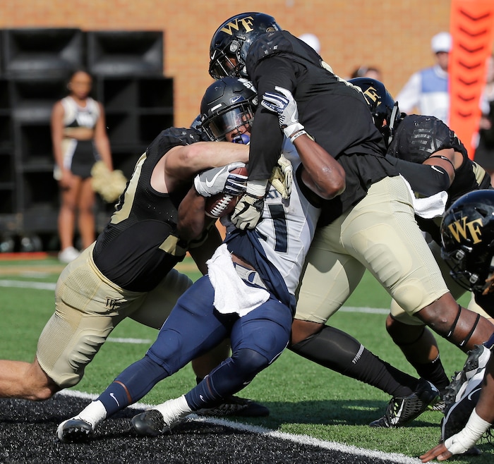 Utah State's LaJuan Hunt, center, is stopped in the end zone for a safety by Wake Forest players Grant Dawson, left, and Carlos Basham Jr., right, in the first half of an NCAA college football game in Winston-Salem, N.C., Saturday, Sept. 16, 2017. (AP Photo/Chuck Burton)