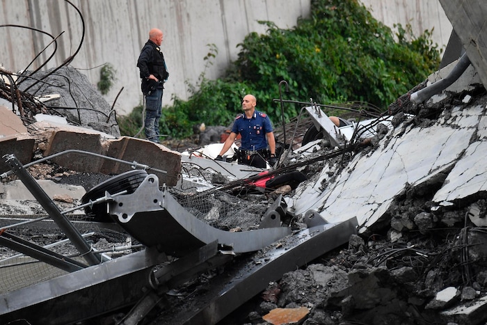 Rescues work among the debris of the collapsed Morandi highway bridge in Genoa, Tuesday, Aug. 14, 2018. Italian authorities say that about 10 vehicles were involved when the raised highway collapsed during a sudden and violent storm in the northern port city of Genoa, while private broadcaster Sky TG24 said the collapsed section was about 200-meter long (650 feet). (Luca Zennaro/ANSA via AP)