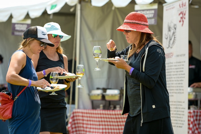 Leah Hogsten | The Salt Lake Tribune l-r Annaliese Eichelberger, Diana Colby and Kristen Kenley grab a quick bite to eat while volunteering at the annual Taste of the Wasatch food and wine event Sunday, August 5, 2018 at Solitude.