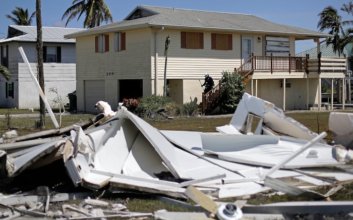 A member of the Arizona Task Force 1 search and rescue team knocks on doors while checking on homes and their owners after Hurricane Irma in Goodland, Fla., Tuesday, Sept. 12, 2017. (AP Photo/David Goldman)