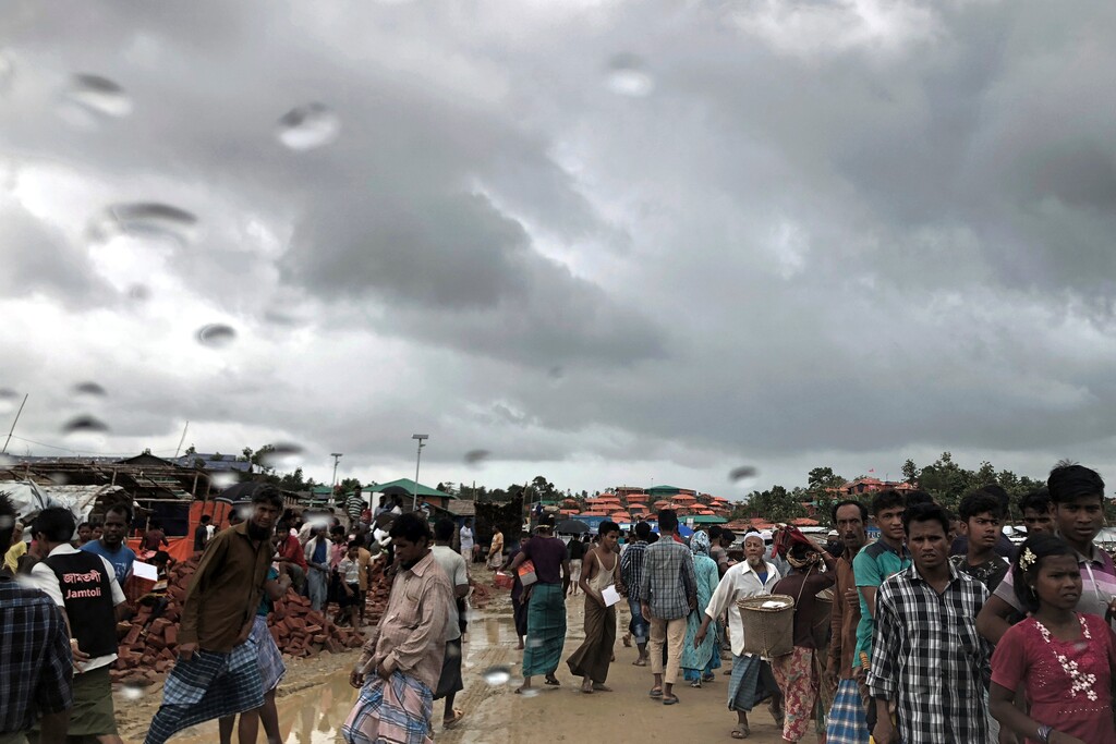 (Wong Maye-E | The Associated Press) In this Tuesday, June 26, 2018, photo, Rohingya refugees walk on a muddy road in the rain through Jamtoli refugee camp in Bangladesh. For the hundreds of thousands of Rohingya children living in Bangladesh's refugee camps, dangers lurk everywhere: from malnutrition and disease to human traffickers to flooding and landslides.