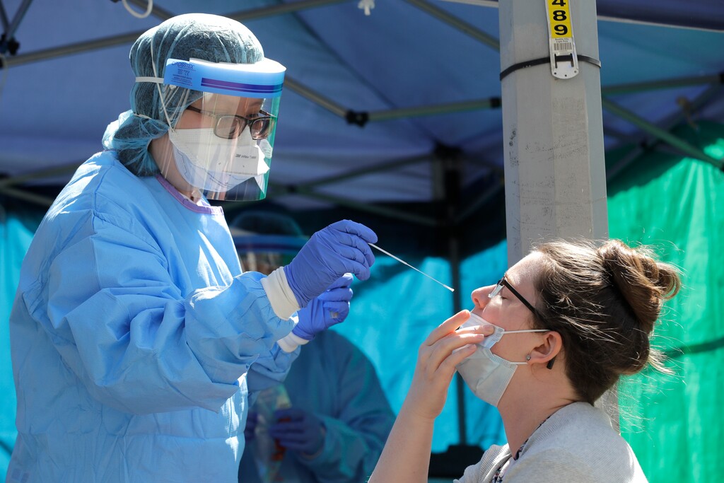 (Ted S. Warren | The Associated Press)
Tina Nguyen, left, a nurse at at the International Community Health Services clinic in Seattle's International District, takes a nose swab sample from Mindy Balk, an ICHS employee, during walk- and drive-up testing for COVID-19, Friday, May 15, 2020. As testing supplies for coronavirus have become more abundant, the clinic has been able to offer testing to anyone in the community by appointment if they are experiencing symptoms.