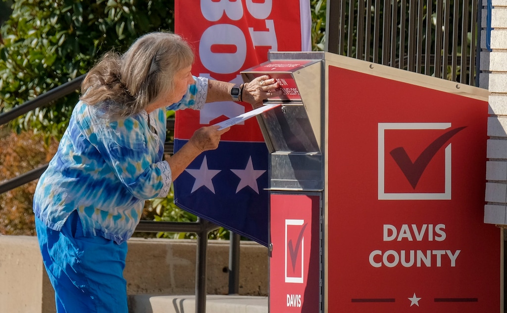 (Leah Hogsten  |  Tribune file photo) This Nov. 3, 2020, photo shows a voter dropping off her ballot at the Davis County Library's South Davis Branch in Bountiful. Under a bill given final legislative approval Wednesday, voters would be blocked from switching parties for nearly three months before a June primary election.