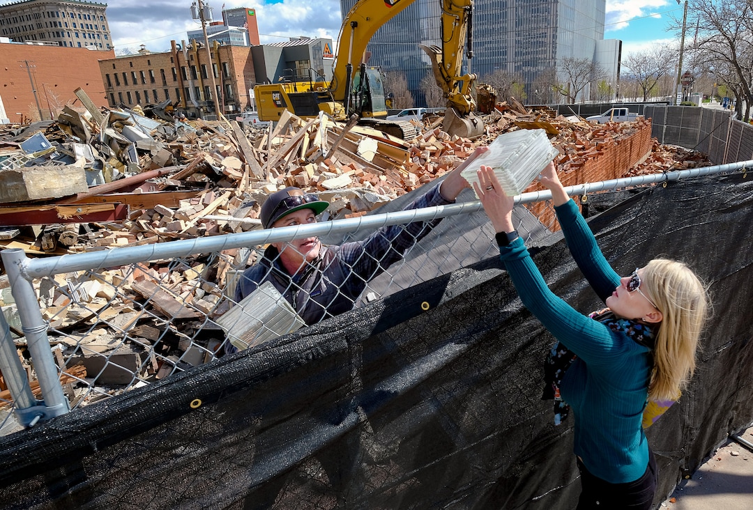 (Francisco Kjolseth  |  The Salt Lake Tribune) Michael Lund and Heather Johnson score a few souvenir glass blocks as crews take down the old Zephyr Club at 301 S. West Temple in Salt Lake City on Thursday, April 2, 2020. Sources say the building had substantial roof damage, unrelated to the recent earthquake, and will be replaced for now with landscaping.