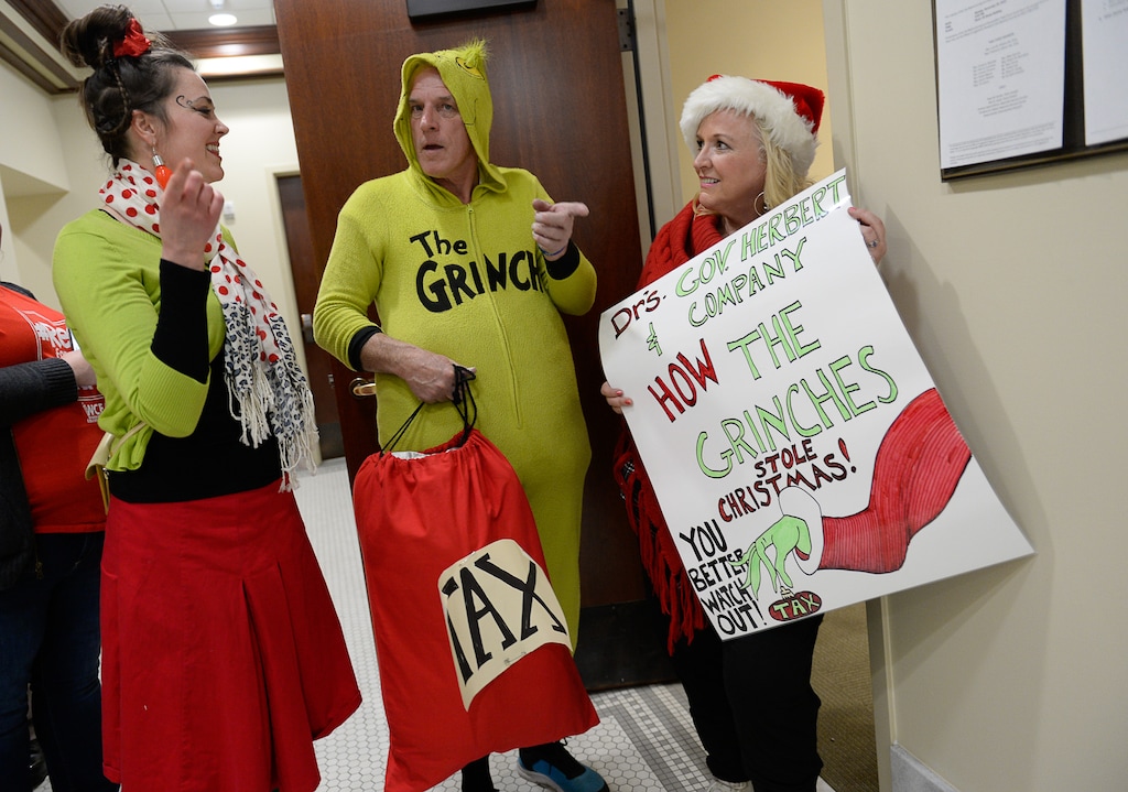(Francisco Kjolseth | The Salt Lake Tribune)  Jonalee Tobias, Greg Zenger and Stephanie Clancy, from left, depict The Grinch as they attend the tax reform task force arriving to speak in what what may be its final meeting at the Utah Capitol on Monday, Nov. 25, 2019.