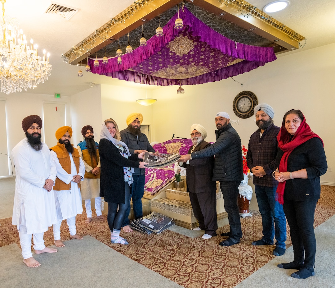 (Rick Egan | The Salt Lake Tribune) Members of the Sikh community present wool blankets to Carin Crowe, of Habitat for Humanity, to distribute to help the unsheltered stay warm during a blessing ceremony at the Sikh temple in Taylorsville, on Thursday, Dec. 23, 2021.
