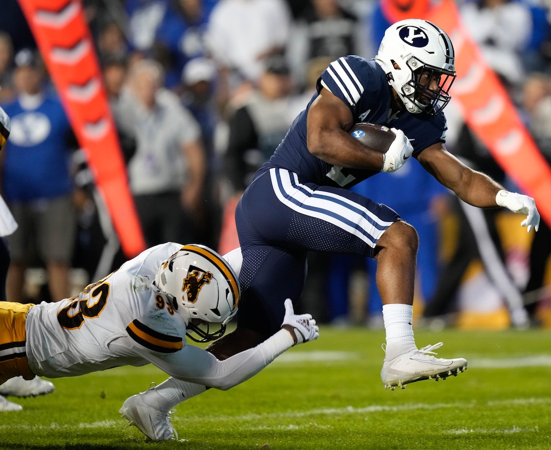 (Francisco Kjolseth | The Salt Lake Tribune) Brigham Young Cougars running back Christopher Brooks (2) steps away from Wyoming Cowboys defensive end DeVonne Harris (93) setting up the football for a touchdown on the next play in football action between the Brigham Young Cougars and the Wyoming Cowboys at LaVell Edwards Stadium in Provo, on Saturday, Sept. 24, 2022.