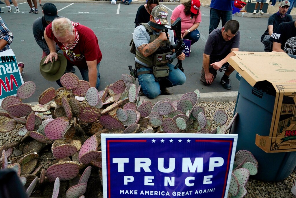 Supporters of President Donald Trump pray at a rally outside the Maricopa County Recorder's Office, Friday, Nov. 6, 2020, in Phoenix. (AP Photo/Ross D. Franklin)