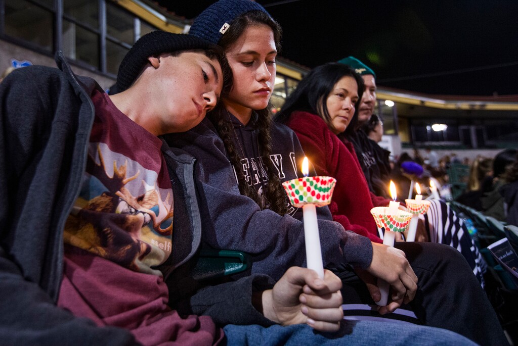 (Tom Tingle | The Arizona Republic via The Associated Press) The McIntyre family from Redlands, Calif., hold candles at a vigil at San Manuel Stadium Thursday, Dec. 3, 2015, in remembrance of the 14 people lost Wednesday in the San Bernardino mass shooting. From left to right, Patrick,11, Kathleen, 13, (sister), Renee and Joe. The parents are middle school teachers.