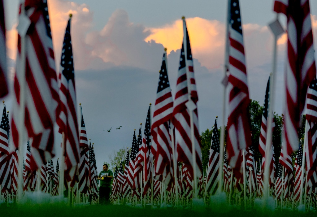 (Francisco Kjolseth | The Salt Lake Tribune) The sun rises on Saturday, Sept. 11, 2021, as people visit the Utah Healing Field in Sandy, part of the nonprofit Colonial Flag Foundation, which posted 3,000 flags to honor the fallen. The display is free to the public and open through Sept. 13.