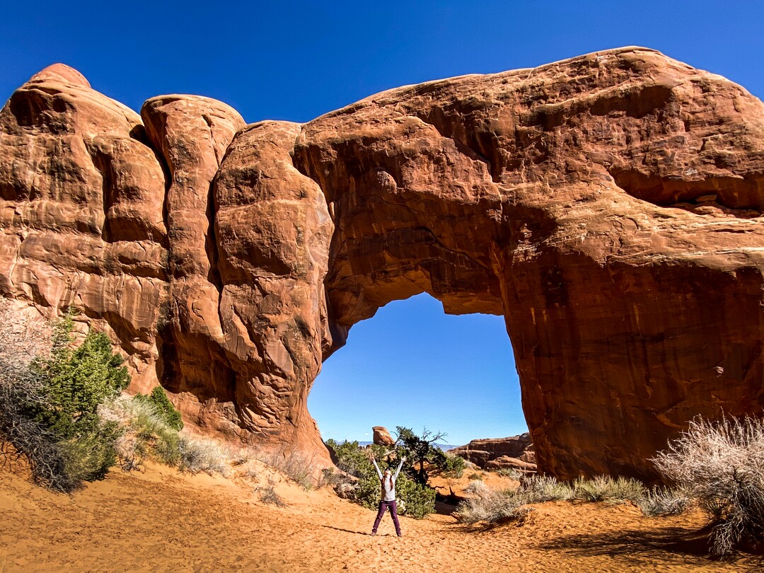 (Emily Pennington  |  Little A) Emily Pennington poses under one of the natural arches in Arches National Park. Pennington has written a memoir, "Feral," about her experience visiting all the national parks in the United States.