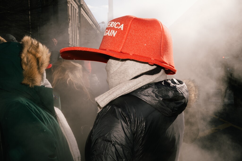 A supporter in an oversized MAGA hat tries to stay warm on Pennsylvania Avenue on the day of President Donald Trump's second inauguration, Jan. 20, 2025.(Paola Chapdelaine/The New York Times)