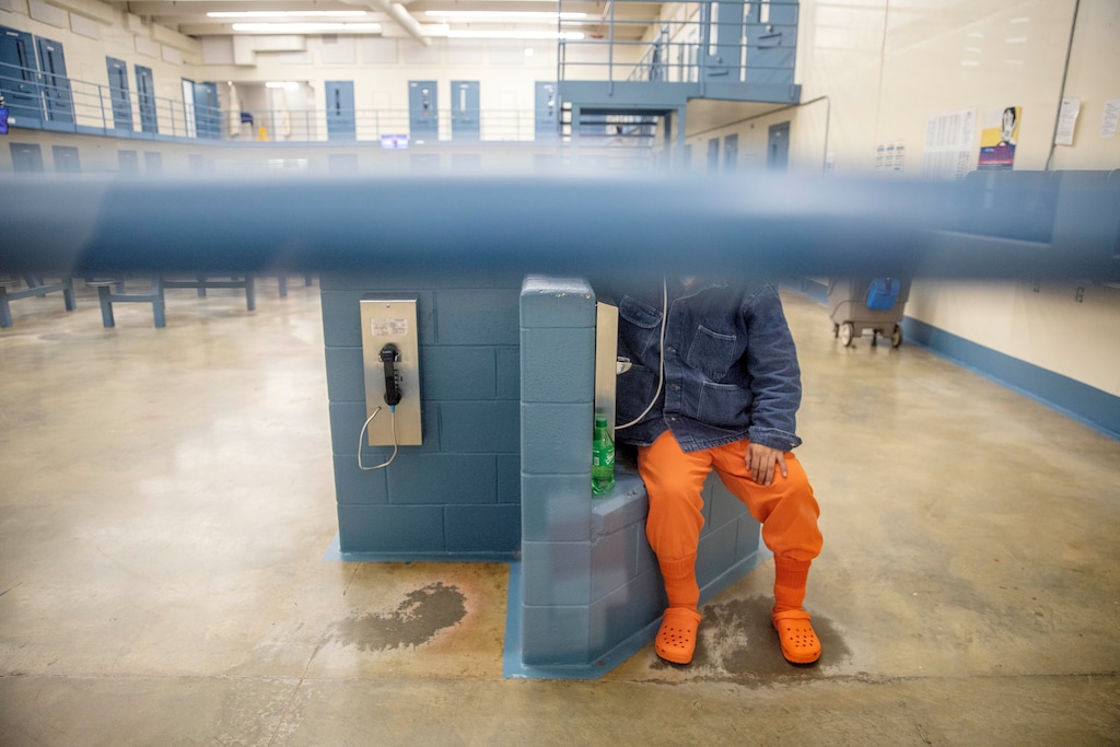 (David Goldman | AP) A detainee talks on the phone in his pod at the Stewart Detention Center, Friday, Nov. 15, 2019, in Lumpkin, Ga. It's difficult for detained immigrants to see or even speak to lawyers who live far away, and they have no access to email or fax and the phones sometimes don't work or are expensive, according to the Southern Poverty Law Center attorney Erin Argueta, one of three attorney's who work full time in Lumpkin. Communications have to be sent by mail, which slows the process of collecting documentation, filling out forms in English and getting documents translated and notarized.